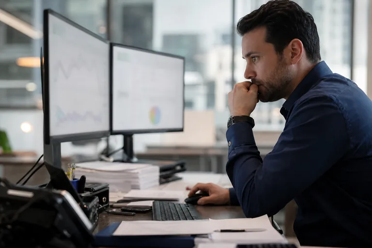 Compliance analyst reviewing a wallet risk alert on two monitors